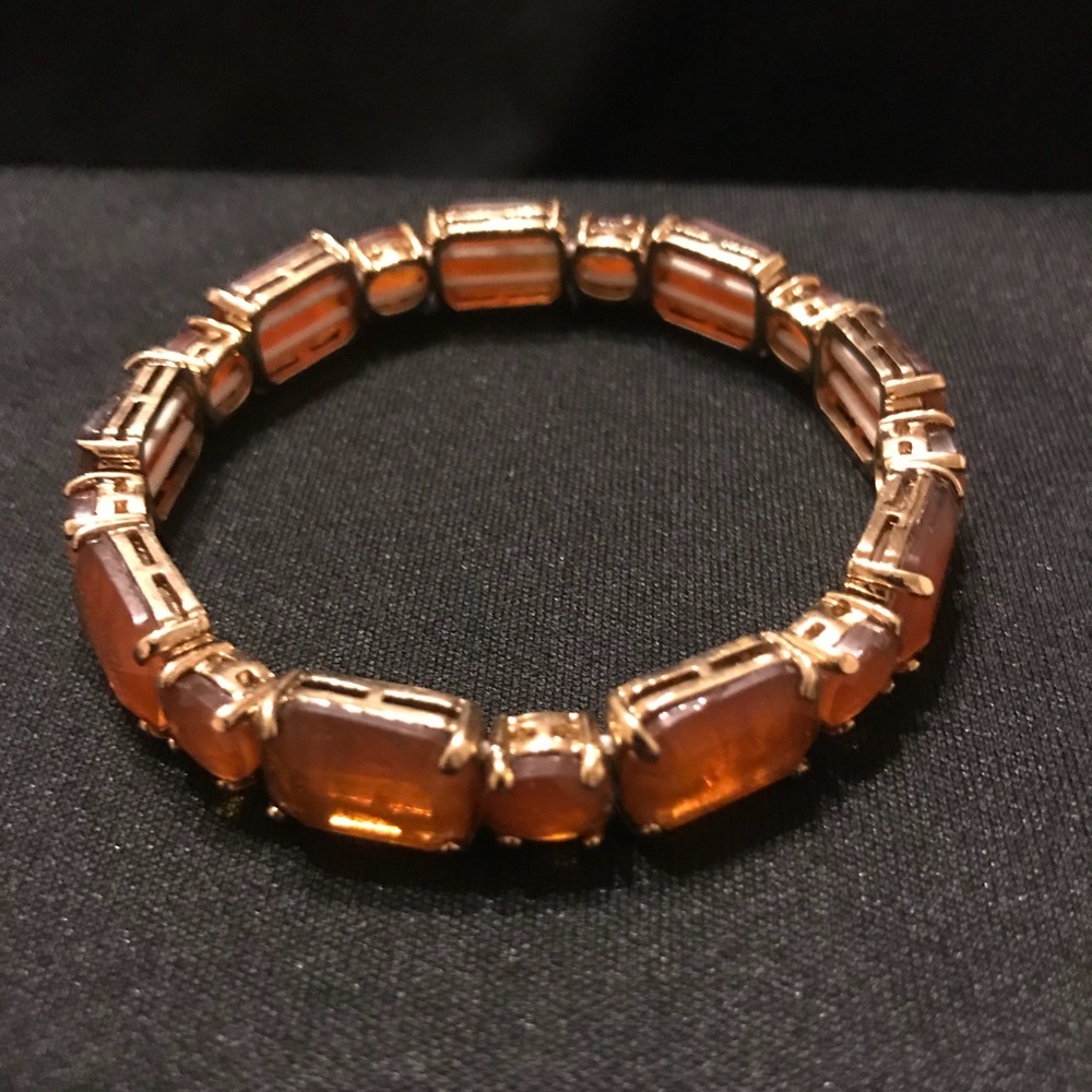 Gold tone bracelet with orange stones.